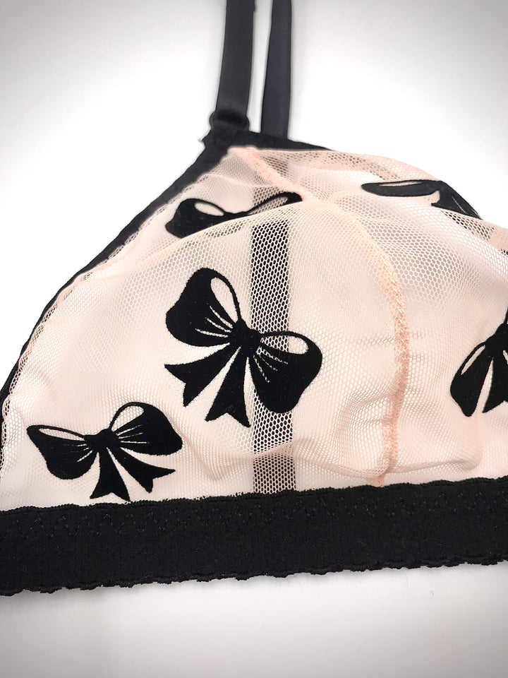 Peachy pink sheer mesh bralette with black velvet bow appliqué